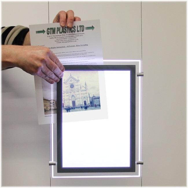 Person removing film from LED lightbox when it's plugged in and illuminated