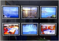 Illuminated backlit film placed within single-sided light-pockets being displayed in a yacht brokers window