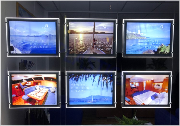 Illuminated backlit film placed within single-sided light-pockets being displayed in a yacht broker's window