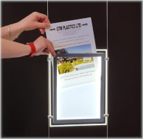 A person using their hands to remove backlit film from a light pocket